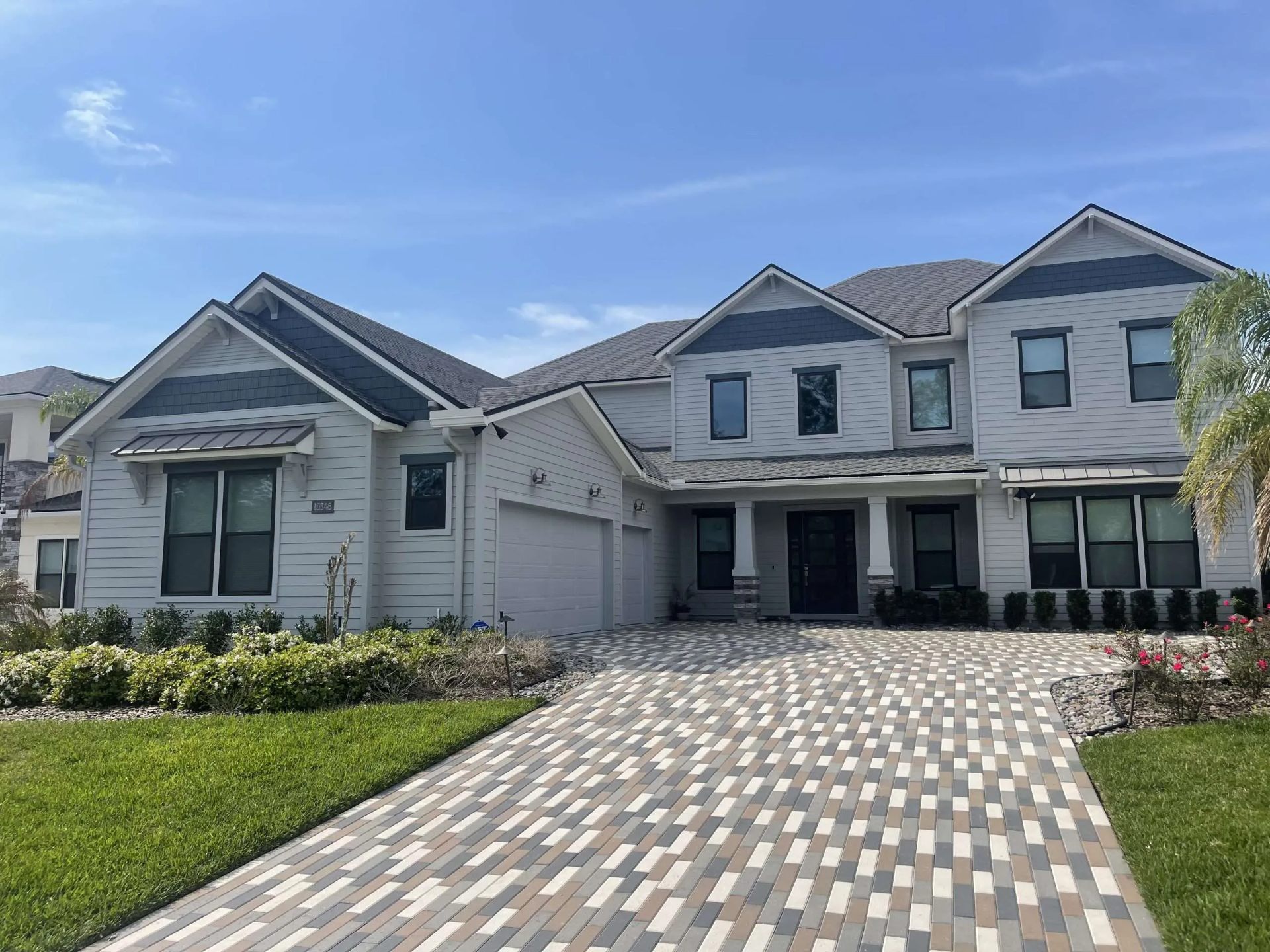 Beautiful home with modern garage doors and paver driveway